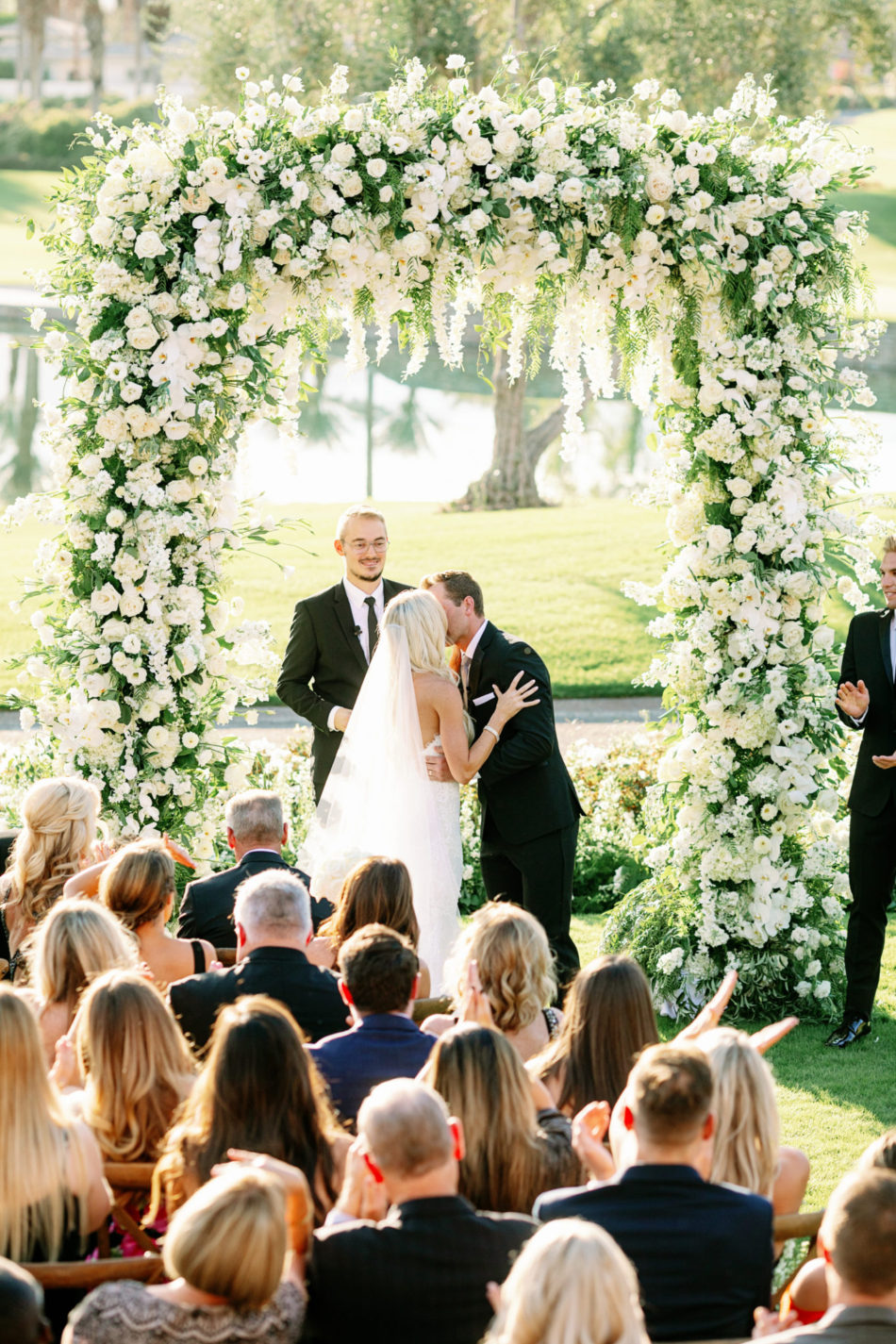 first kiss, bride and groom, floral-filled arch, exquisite white wedding, floral design, florist, wedding florist, wedding flowers, orange county weddings, orange county wedding florist, orange county florist, orange county floral design, flowers by cina