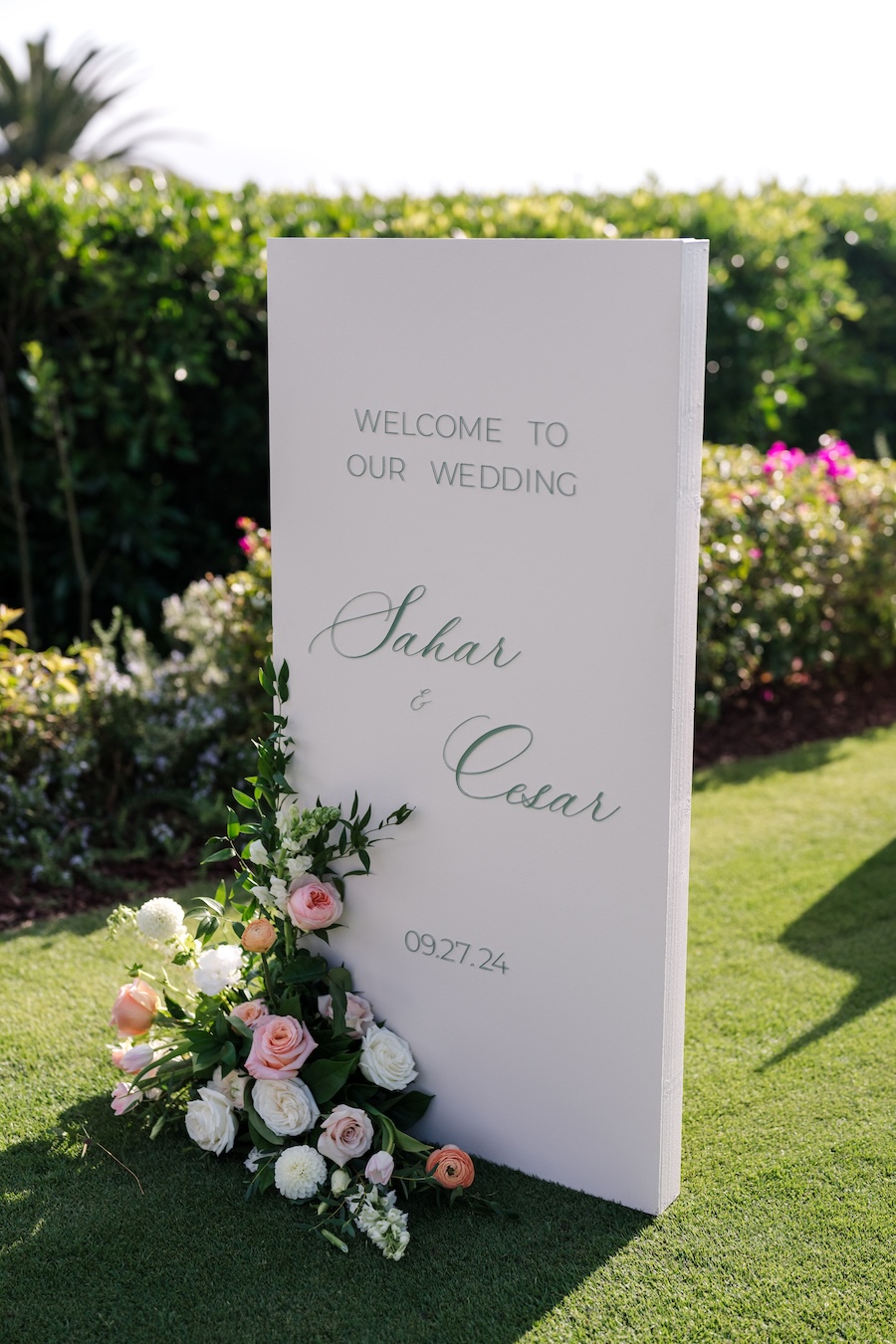 Sign welcoming guests to Montecito Club wedding with floral details. 